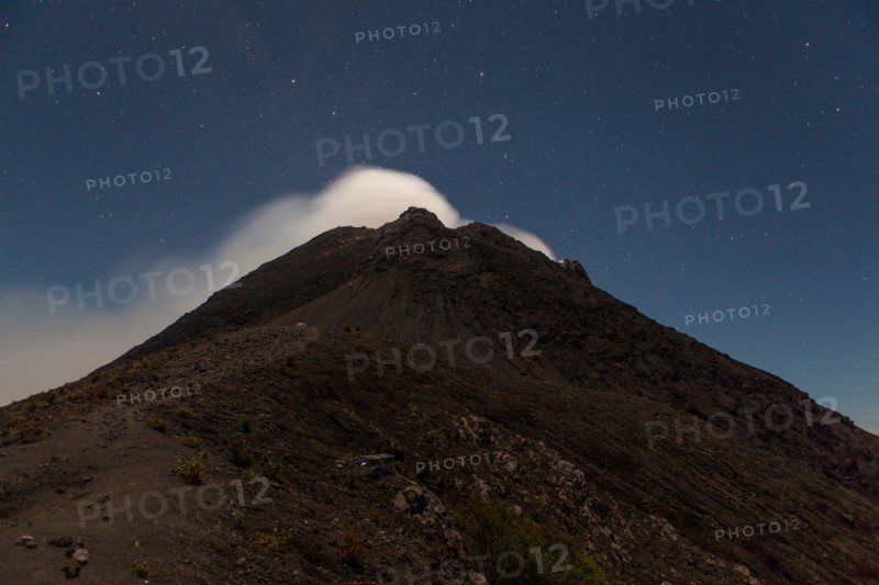 Smoke from Merapi volcano under stars at night.