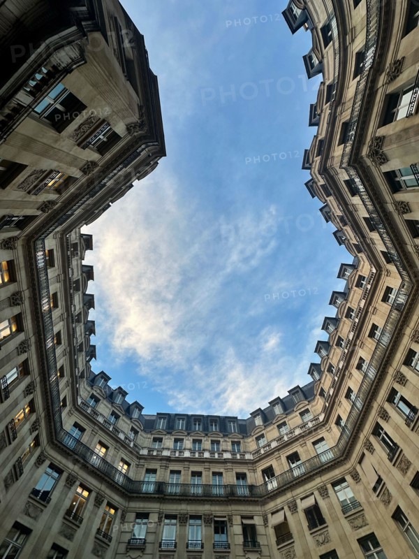 Unique perspective of the sky framed by unusual-shaped buildings in Paris – urban architecture and dramatic angles.