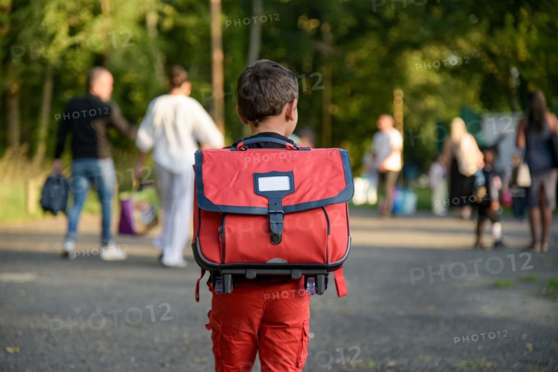 view of a child going to school with a schoolbag on his back on the first day of school in France