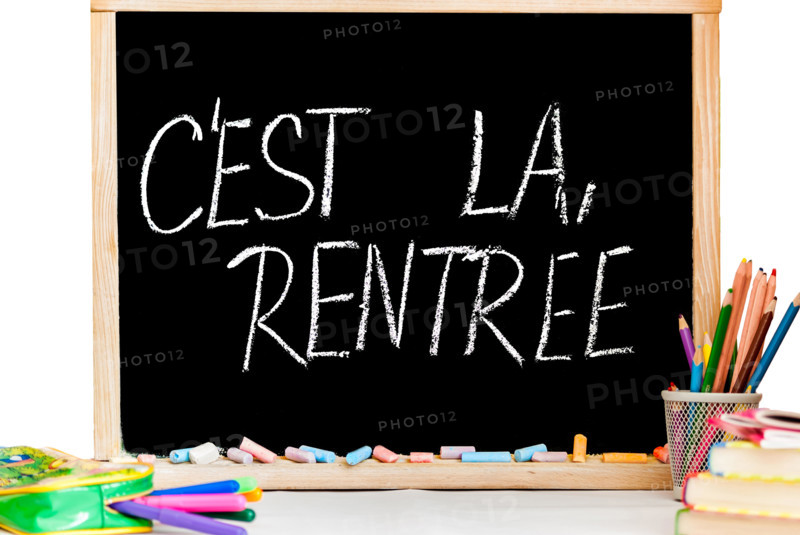 Back to school in french on black chalkboard and color chalk