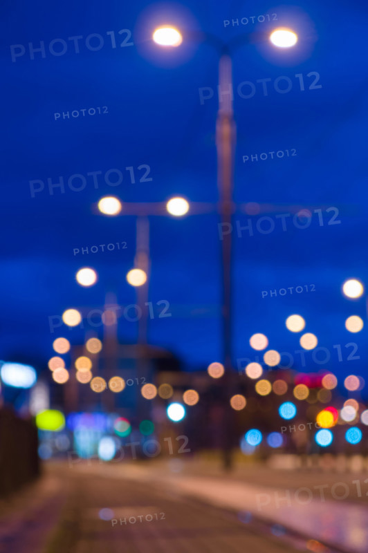 Blurred image of night city street with lamppost lights