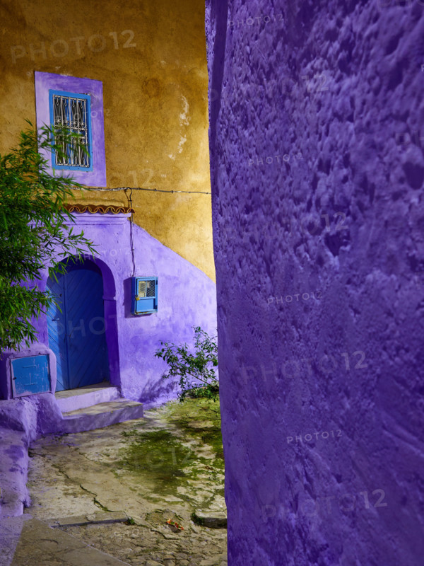 Yellow and violet walls, blue door, fragment of the medina of Chefchaouen, night photography, Morocco.