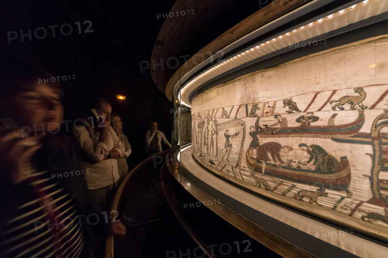 Bayeux, France. Visitorswalk past the famous tapestry (Tapisserie) of Bayeux,1000 year old carpet telling the story of the Norman conquest of England