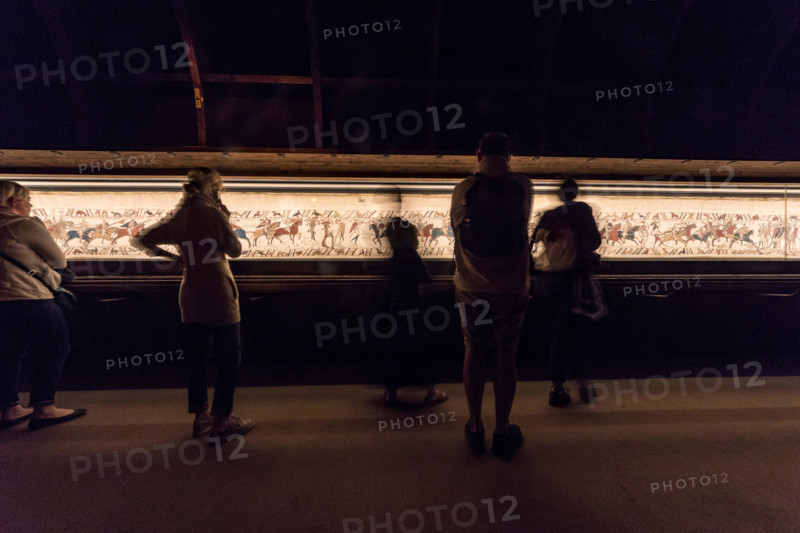 Bayeux, France. Visitorswalk past the famous tapestry (Tapisserie) of Bayeux,1000 year old carpet telling the story of the Norman conquest of England