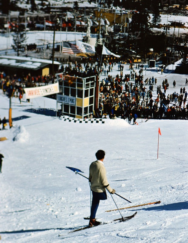 1960 Winter Olympics in Squaw Valley California: One legged skier watching skiers on the slalom course