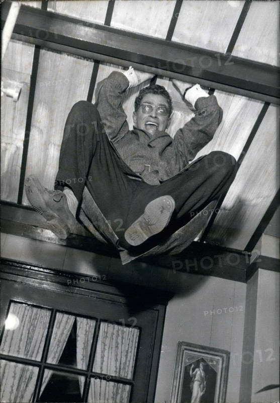 Aug. 17, 1960 - Darry Cowl is pictured in a funny scene in which he hangs from the ceiling in Jacques Poitrenaud's movie ''Paris Loves'