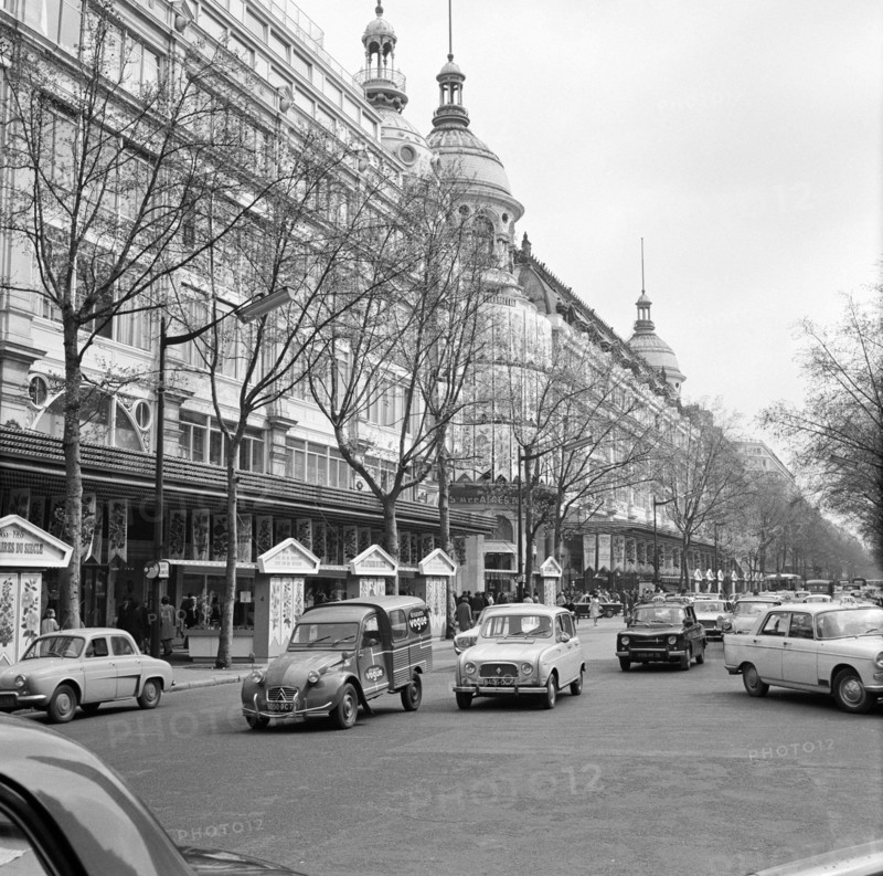 Pariser Bilder [The street life of Paris]  Department stores Printemps and Lafayette on Boulevard Hausmann Date: 1965 Location: France, Paris Keywords: cars, buildings, street statues, department stores