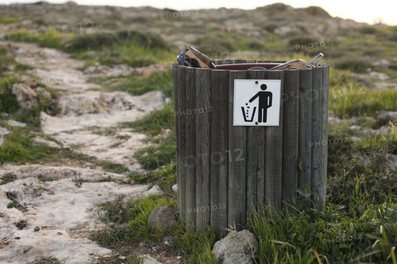 wooden trash or litter bin with for bottle, beer can and organic waste visibile showing pollution in coastal areas near the sea