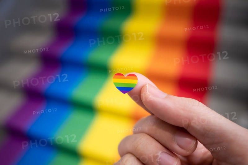 Heart shaped rainbow sticker in a hand for pride month celebration