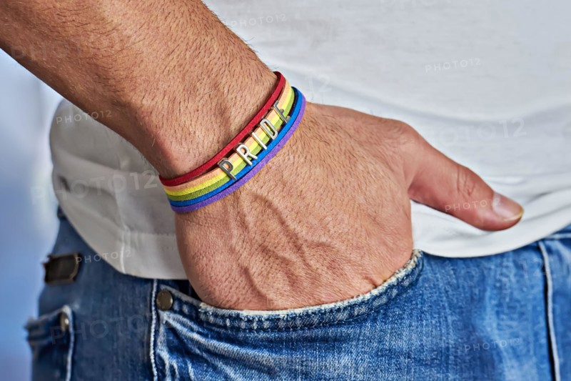 Male hand with rainbow bracelet and text pride in pocket of jeans. Freedom and LGBT concept