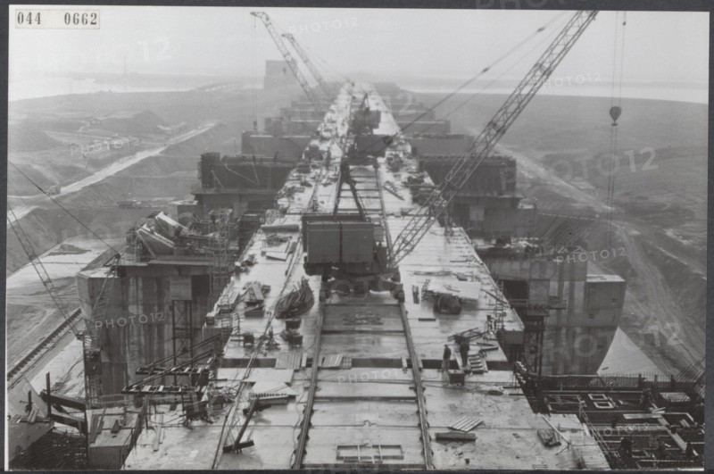 Haringvliet Description: The construction of the spice lice, which form part of the closure of the Haringvliet, one of the parts of the Delta plan, is in advanced stages. In the concrete dams are placed locks that must ensure proper drainage. The locks supplied by Werkspoor will be installed in August. Date: 17 February 1964 Location: Haringvliet, Zeeland Keywords: construction, locks Institution name: Deltawerken
