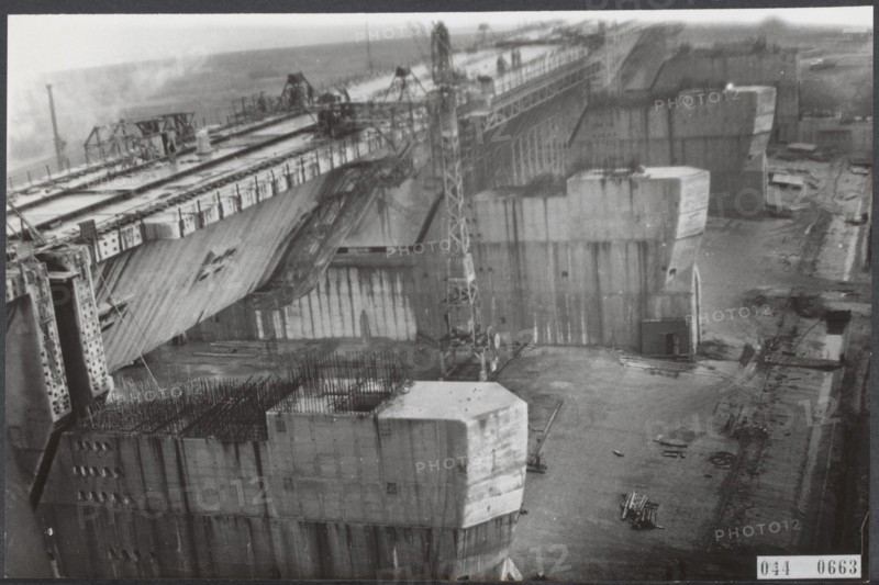 Haringvliet Description: The construction of the spice lice, which form part of the closure of the Haringvliet, one of the parts of the Delta plan, is in advanced stages. In the concrete dams are placed locks that must ensure proper drainage. The locks supplied by Werkspoor will be installed in August. Date: 17 February 1964 Location: Haringvliet, Zeeland Keywords: construction, locks Institution name: Deltawerken