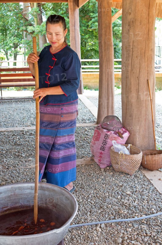 A woman mixes assorted cocoa beans in a sauce to make chocolate