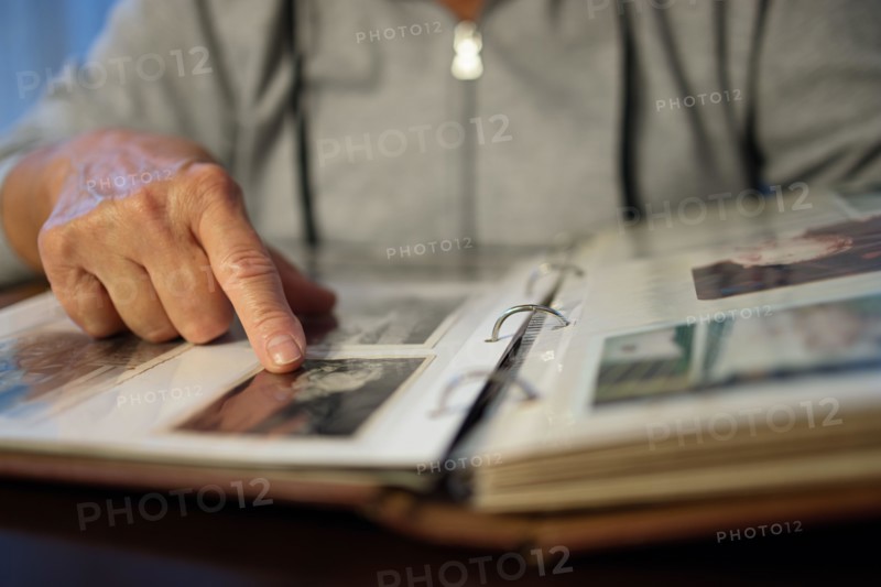 Old woman looking at family photo album