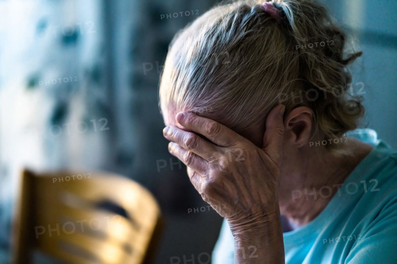 Sad senior old woman. Lonely from loss or sick with headache. Upset patient in retirement home with stress or pain. Alzheimer, depression, senility.