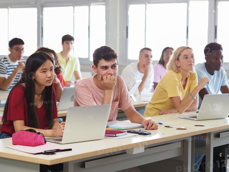 Group of multi-ethnic teenage student listening to the lesson in class
