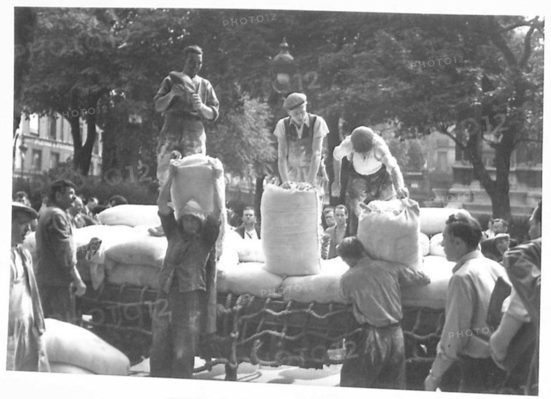 British Army personnel unload sacks of flour at Les Halles market in Paris, providing food supplies during World War II under the 21st Army Group.