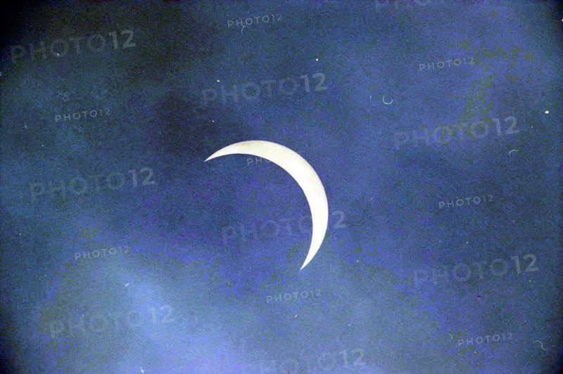 Eclipse in Northern France, 10-08-1999 Whizgle News, Dutch Desk, The Netherlands, 1950-2000 A delicate crescent moon glimmers softly against a serene blue sky, evoking a sense of calm and wonder.