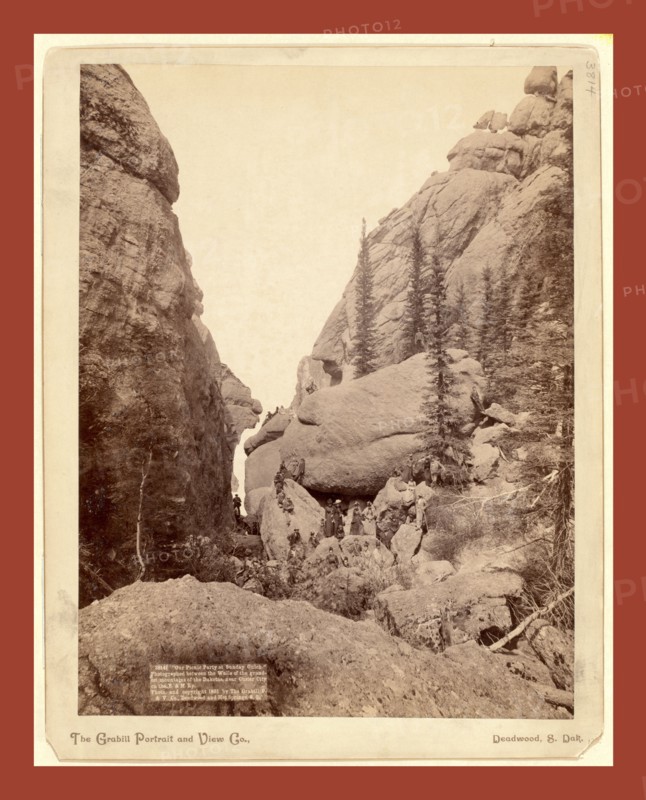 Our picnic party at Sunday Gulch. Photographed between the walls of the grandest mountains of the Dakotas, near Custer City on the B. & M. Ry, John C. H. Grabill was an american photographer. In 1886 he opened his first photographic studio