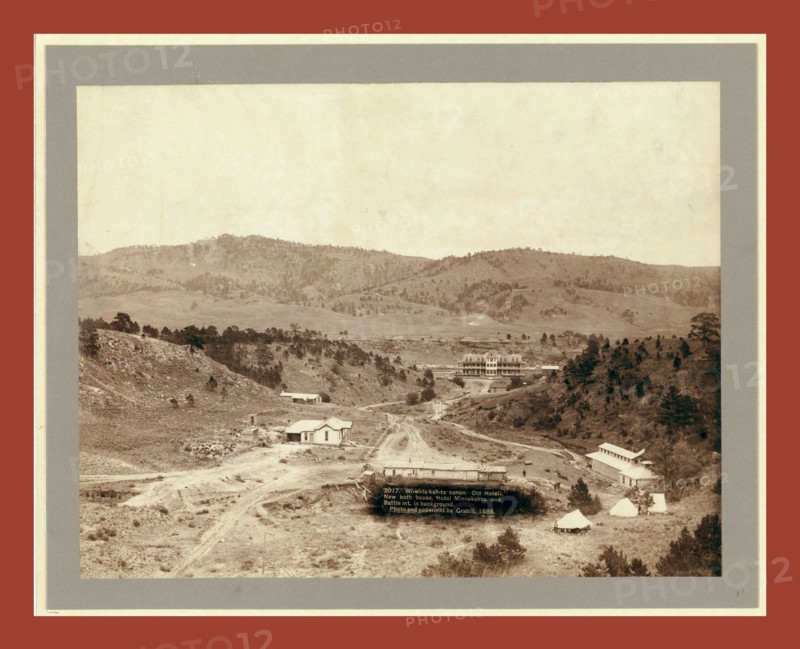 Wi-wi-la-kah-ta canon. Old hotel, new bath house, Hotel Minnekahta and Battle Mt. in background, John C. H. Grabill was an american photographer. In 1886 he opened his first photographic studio