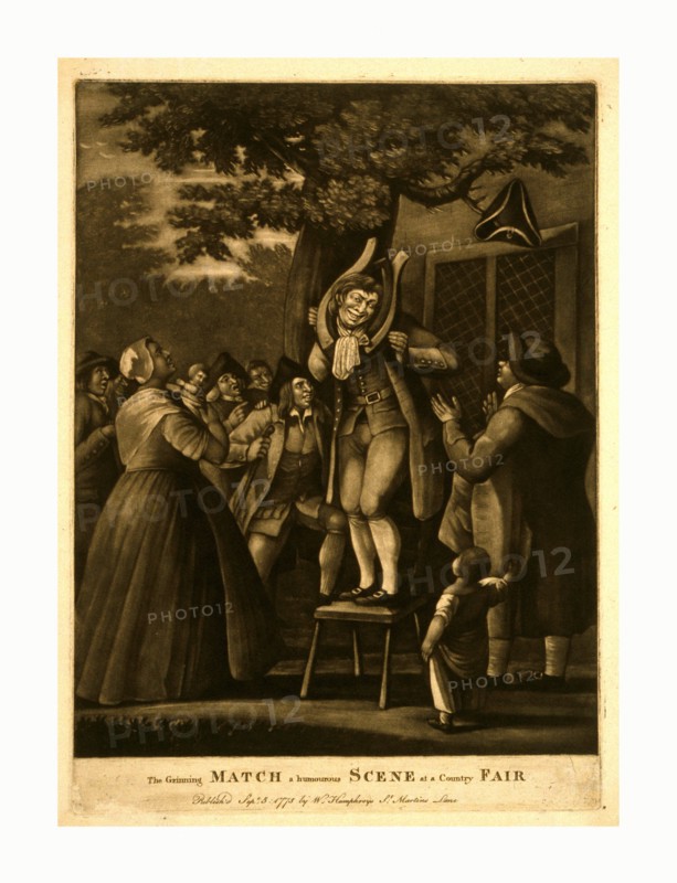 The grinning match, a humourous scene at a country fair, engraving 1775, mezzotint., A man stands on a chair beneath a large, spreading tree on which a tri-corn hat hangs from a limb, his grinning face framed by a horse-collar, a woman and a man look on in the foreground, the man applauds, while a crowd of countrymen on the left, in the rear, encourage him with laughter and applause; with building on the right, in the background.