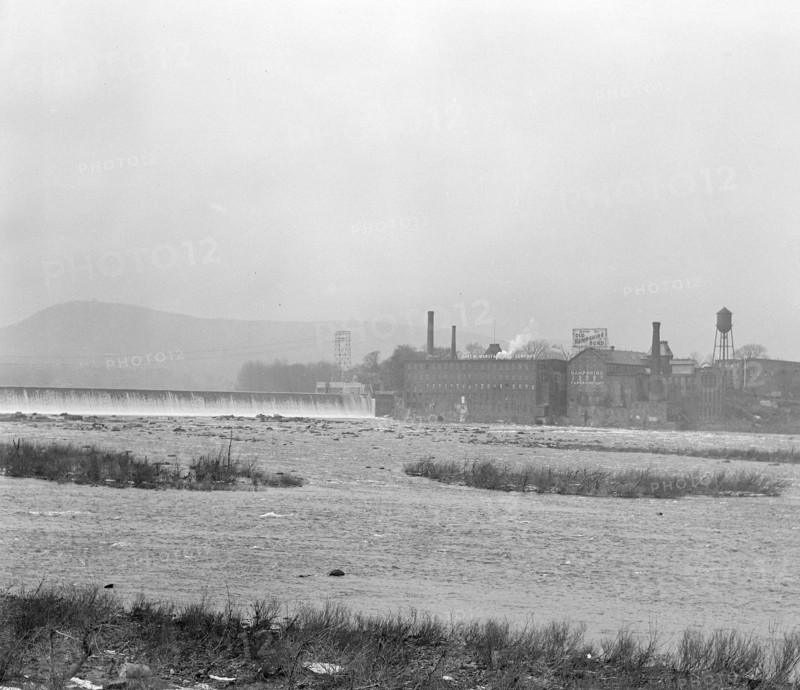 Mt. Holyoke, Massachusetts - Scenes. The dam: The Connecticut River: the old and famous Hampshire bond manufacturing plant, recently bought by its neighbor, Carew Manufacturing. Also an old and independent mill; founder paternalistic enough to build a church which still stands, enough local feeling to employ from South Hadley because on the Hadley side of the River - Carew Manufacturing Company, 1936 , Lewis Hine, 1874 - 1940, was an American photographer, who used his camera as a tool for social reform. US,USA