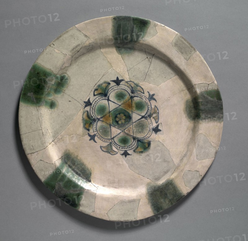 Earthenware Dish Painted Blue with Splashes of Green and Yellow, 830-900. Iraq, Basra, Abbasid period, 9th Century. Earthenware with overglaze-painted design; diameter: 30.2 cm (11 7/8 in.); overall: 1.3 cm (1/2 in.).