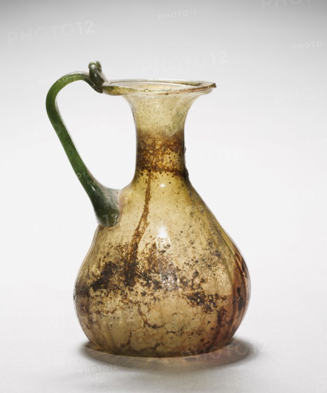 Pitcher with Handle, 300s. Syro-Palestinian, Roman, 4th century. Glass; diameter: 4.8 cm (1 7/8 in.); overall: 12.3 x 8.9 x 7.7 cm (4 13/16 x 3 1/2 x 3 1/16 in.).