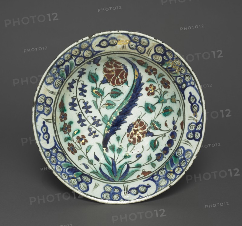 Gilded Dish with Flowers and Leaves, c. 1590. Turkey, Iznik, Ottoman Period, late 16th century. Fritware with red slip, underglaze-painted design, and overglaze gilding; diameter: 29.8 cm (11 3/4 in.); overall: 6.6 cm (2 5/8 in.).