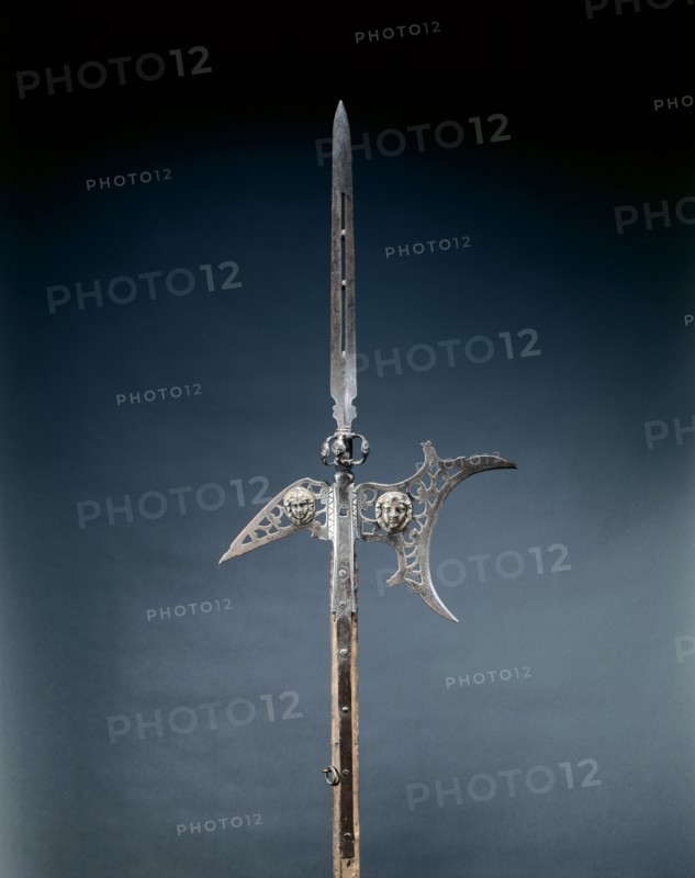 Halberd, c. 1600-1625. France, early 17th century. Steel, pierced; appliqué masks in brass; octagonal wood haft with studs and leather straps; overall: 239 cm (94 1/8 in.); blade: 48 cm (18 7/8 in.).