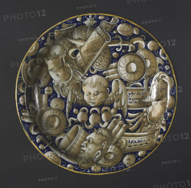 Plate with Putto, Mask, and Trophies, c. 1440-1460. Italy, Castel-Durante, 15th century. Tin-glazed earthenware (maiolica); diameter: 5.6 x 25.7 cm (2 3/16 x 10 1/8 in.).
