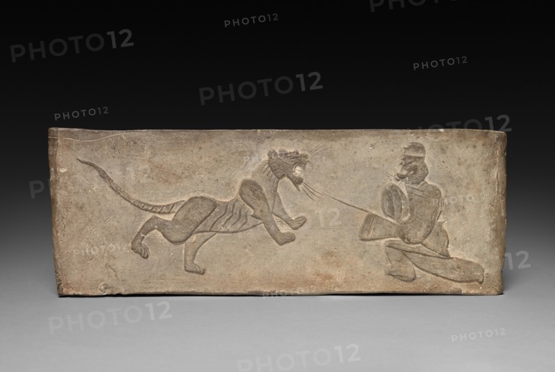 Panel from Model Cooking Stove: Lancer Jousting with a Tiger, 1st Century BC. China, from a tomb in Sian-fu, Shensi province, Western Han dynasty (202 BC-AD 9). Earthenware with impressed relief decoration; overall: 11.4 x 31.1 cm (4 1/2 x 12 1/4 in.).