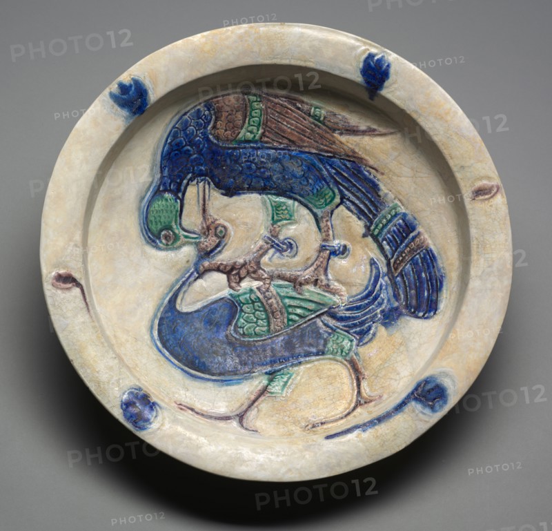 Dish with Falcon Attacking a Water Bird, 1100s. Syria, possibly Tell Minis, Zangid or Ayyubid period. Fritware with carved decoration and underglaze-painted design (Lakabi ware); overall: 8.3 x 40 cm (3 1/4 x 15 3/4 in.).
