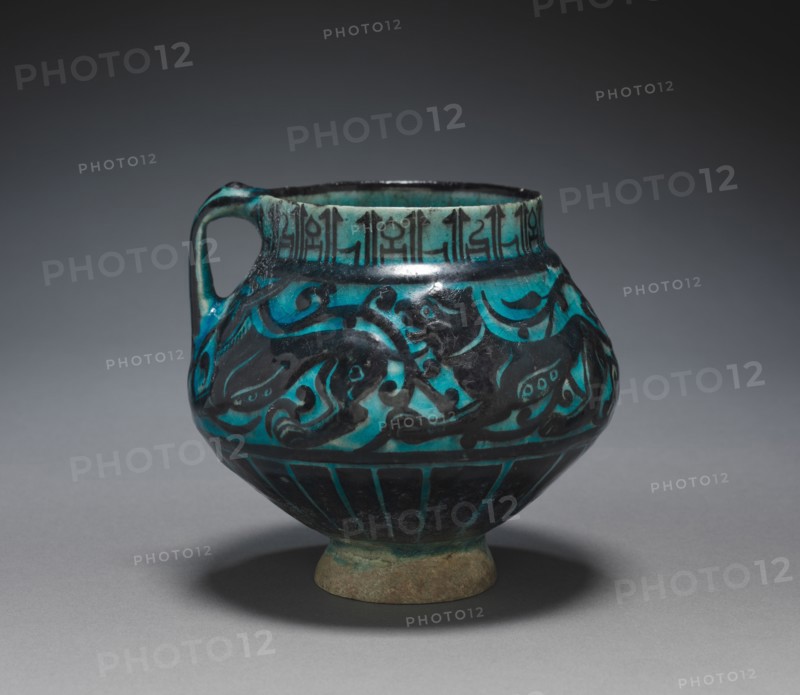 Jug with Running Animals, 1150-1220. Iran, probably Kashan, Seljuk Period, 12th-13th Century. Fritware with design in carved and underglaze-painted slip ("silhouette" ware); overall: 13 x 14 cm (5 1/8 x 5 1/2 in.); diameter of rim: 8.9 cm (3 1/2 in.).