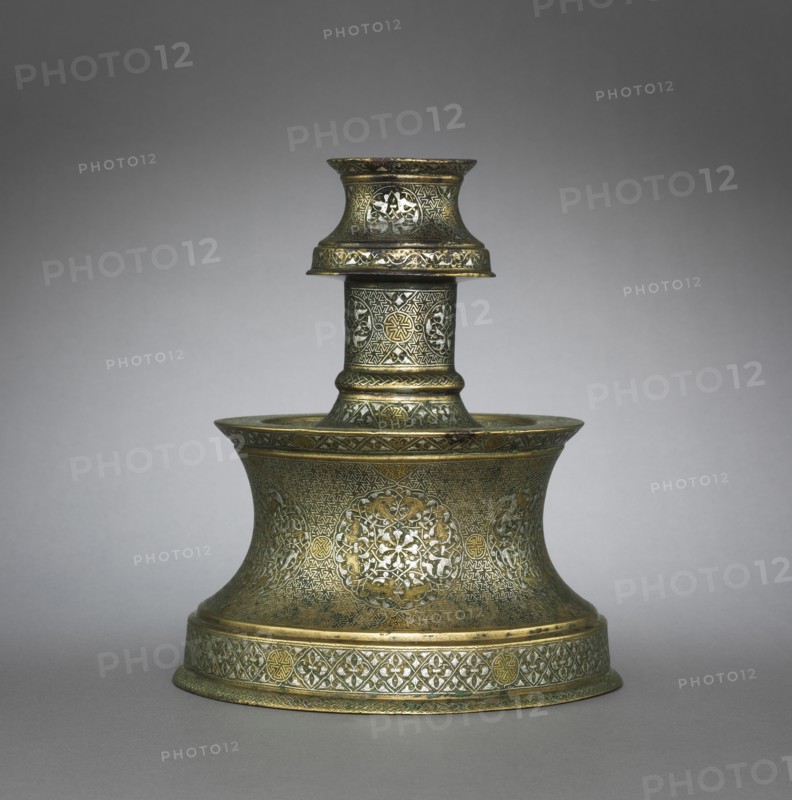 Candlestick, 1250-1350. Eastern Anatolia, mid-13th to mid-14th Century. Sheet brass inlaid with silver; overall: 24.4 cm (9 5/8 in.); diameter of base: 21.3 cm (8 3/8 in.).