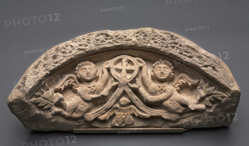 Lunette with Two Angels Supporting a Pendant Cross, 400s. Egypt, 5th century, Coptic period. Limestone; overall: 25.4 x 61 x 21.3 cm (10 x 24 x 8 3/8 in.).