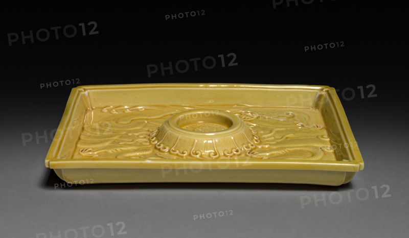 Cup Stand with Dragons in Waves, 1662-1722. China, Jiangxi province, Jingdezhen kilns, Qing dynasty (1644-1912), Kangxi reign (1661-1722). Porcelain with molded decoration and yellow glaze; overall: 1.6 x 10.1 cm (5/8 x 4 in.).