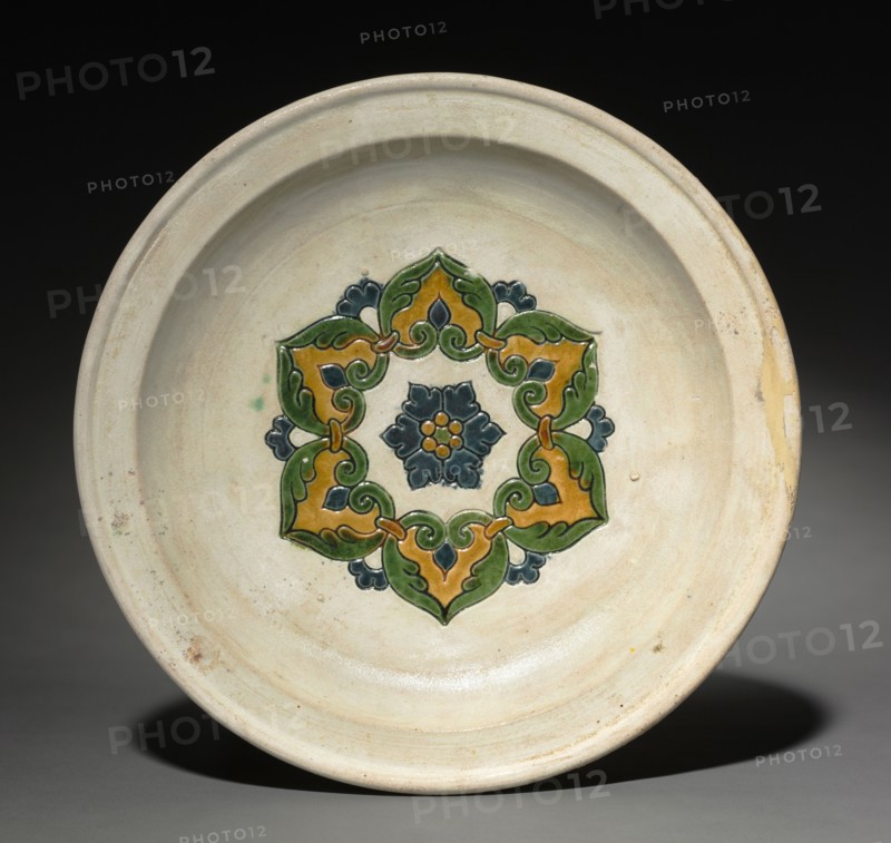 Footed Plate with Floral Medallion, early 700s. China, Tang dynasty (618-907). Glazed earthenware with impressed decoration, sancai (three-color) ware; diameter: 23.9 cm (9 7/16 in.); overall: 5.1 cm (2 in.).