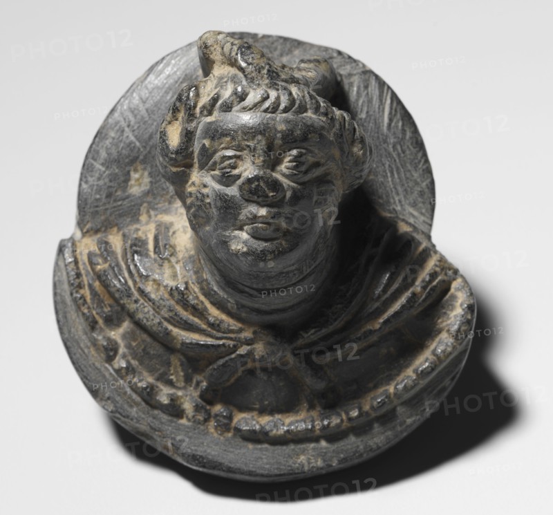 Plaque with a Male Head, 100s. Pakistan, Gandhara, Kushan Period (1st century-320). Gray schist; overall: 7 x 7 cm (2 3/4 x 2 3/4 in.).
