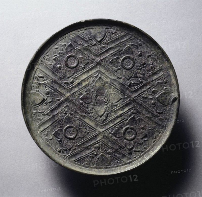Mirror with Five Blossoms and Overlapping Lozenges, 4th century BC. China, Eastern Zhou dynasty (771-256 BC), Warring States period (475-221 BC). Bronze; diameter: 11.4 cm (4 1/2 in.); overall: 0.4 cm (3/16 in.); rim: 0.4 cm (3/16 in.).