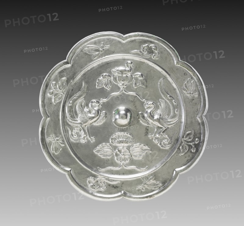 Lobed Mirror with Paired Phoenixes, a Nestling Bird, and a Lotus Blossom, 700s. China, Tang dynasty (618-907). Bronze; diameter: 19.1 cm (7 1/2 in.); overall: 1.1 cm (7/16 in.); rim: 0.7 cm (1/4 in.).