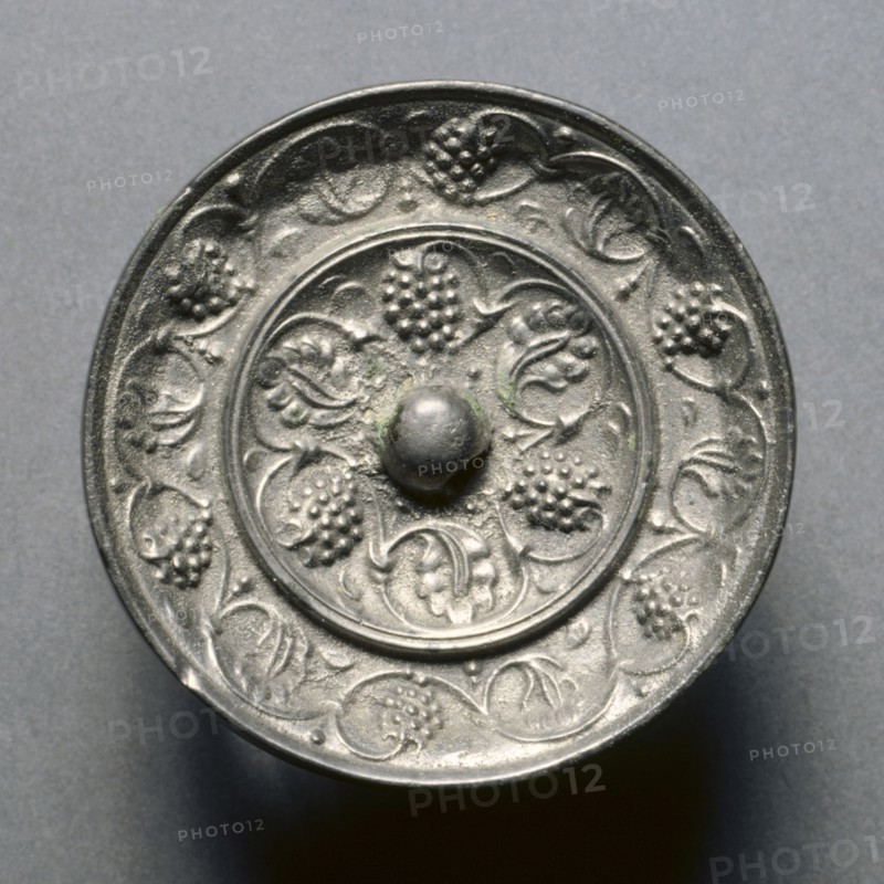 Miniature Mirror with Grape Decoration, 7th century. China, Tang dynasty (618-907). Bronze; diameter: 4.9 cm (1 15/16 in.); overall: 0.7 cm (1/4 in.); rim: 0.7 cm (1/4 in.).