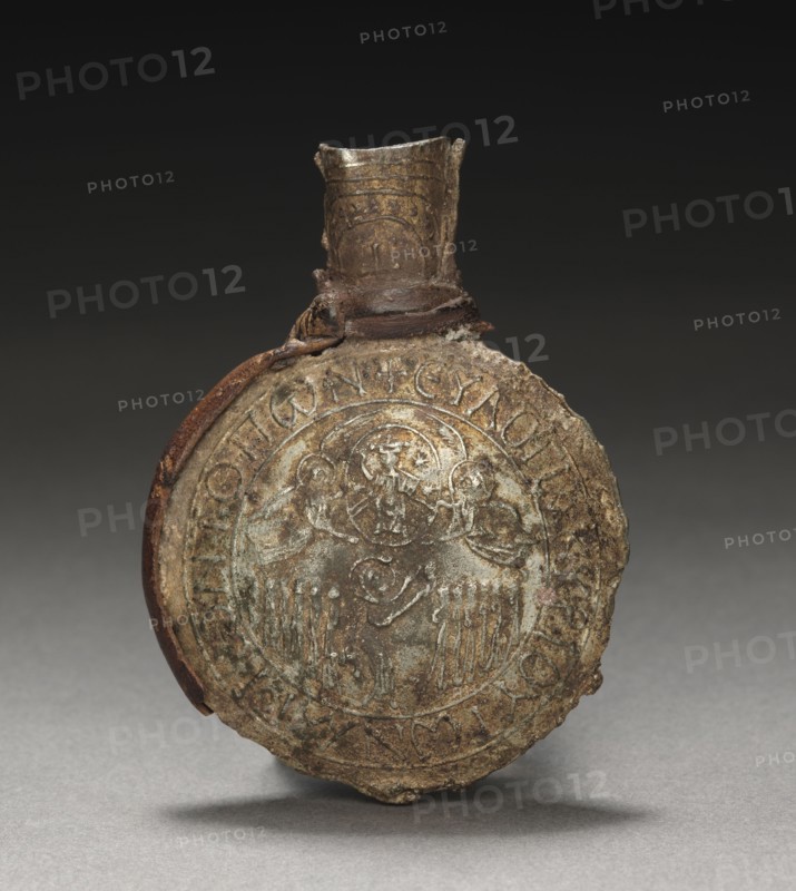 Pilgrim's Ampulla with Scenes of the Crucifixion (front) and the Ascension (back), c. 600. Byzantium; Palestine, early Byzantine period, early 7th Century. Tin-lead alloy with leather fragments; overall: 6.3 x 4.6 x 1.5 cm (2 1/2 x 1 13/16 x 9/16 in.).