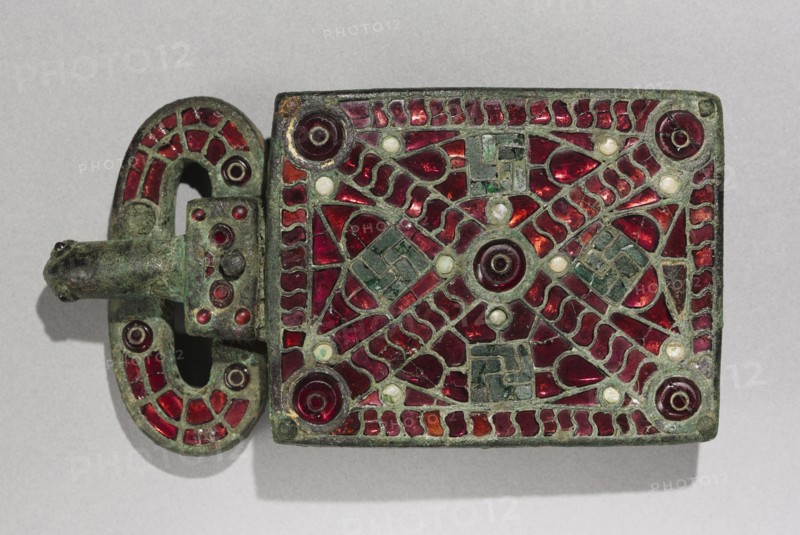 Belt Buckle, c. 525-560. Visigothic, Spain, Migration Period, 6th century. Bronze with garnets, glass, mother of pearl, gold foil, traces of gilding; bronze and glass; overall: 7.1 x 2.7 cm (2 13/16 x 1 1/16 in.).
