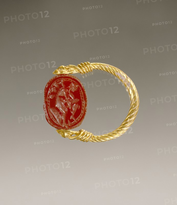 Gem Engraved with a Warrior Putting on Leg Armor; Etruria; 4th century B.C; Carnelian and gold; 0.8 × 1.4 × 1.1 cm
