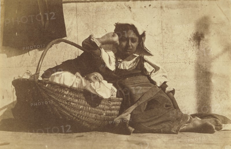 Barefoot girl leaning on basket with a doll; Giacomo Caneva, Italian, 1813 - 1865, Italy; about 1850s; Salted paper print
