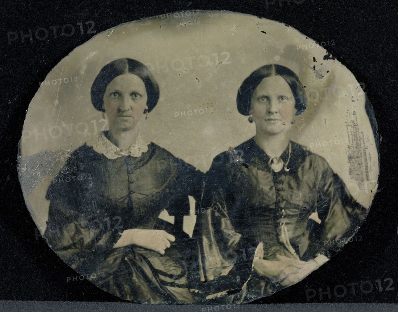 Portrait of Two Seated Women; American; about 1860; Ambrotype, Ruby glass, hand-colored; Glass: 6 x 7.3 cm 2 3,8 x 2 7,8 in