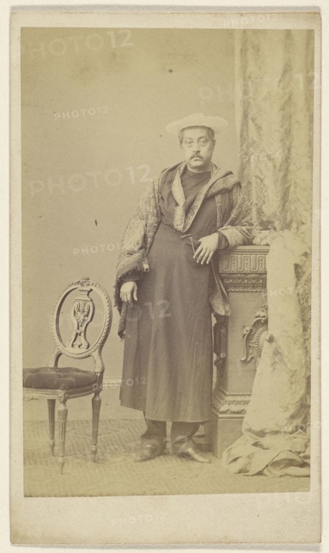 Asian man in robe wearing hat, standing; F. Schwarzschild, British, active Calcutta, India 1860s, 1860s; Albumen silver print