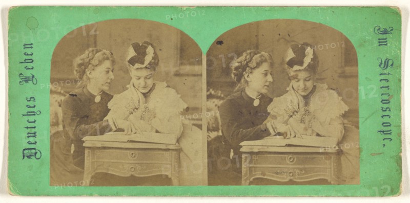 Mother and daughter looking at a book, leaning on a table; German; 1860s; Albumen silver print