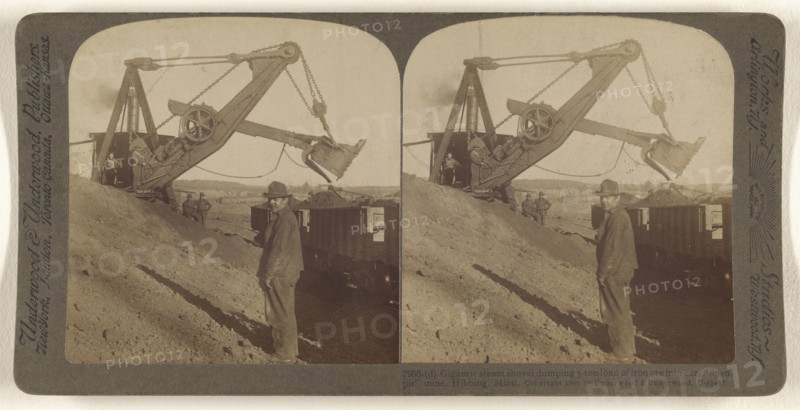 Gigantic steam shovel dumping 5-ton load of iron ore into car,  open-pit  mine, Hibbing, Minn; Underwood & Underwood, American